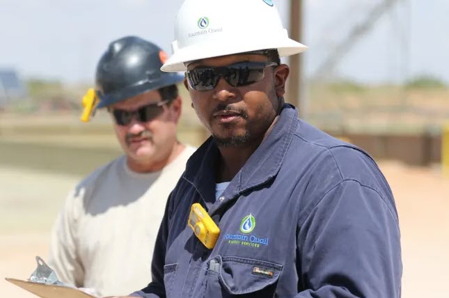 Workers take in a safety briefing at Devon Energy's Todd 2 water recycling facility, 